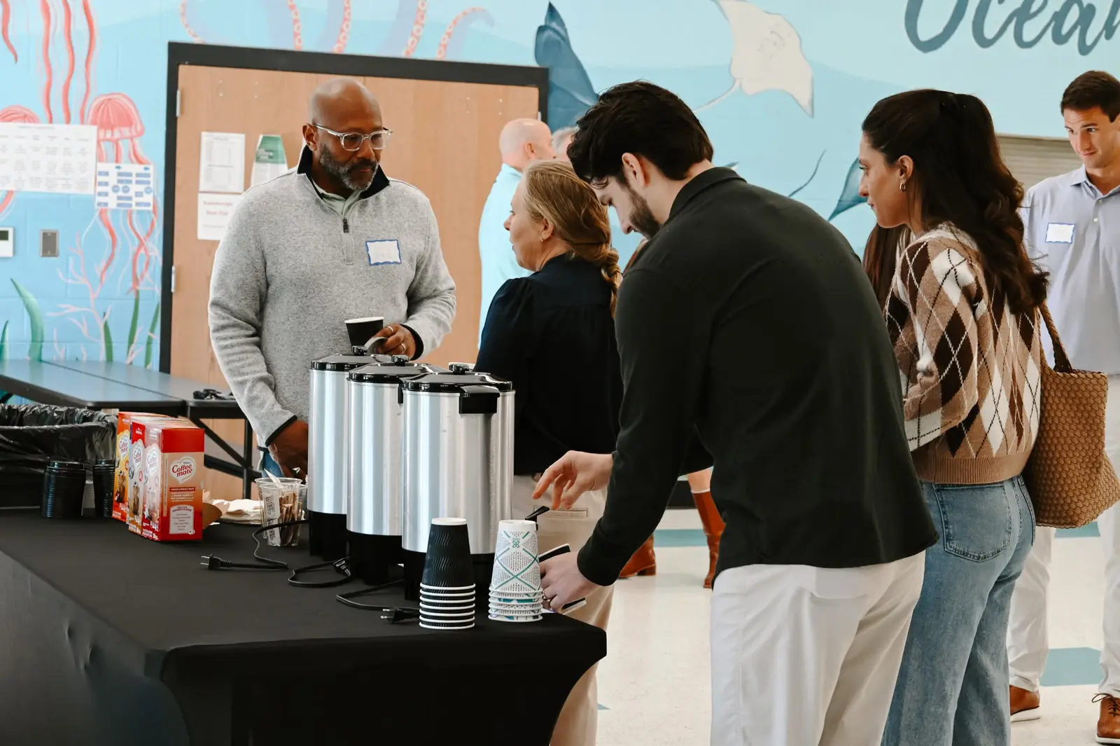 Volunteers serving coffee in the school lobby before a Sunday service
